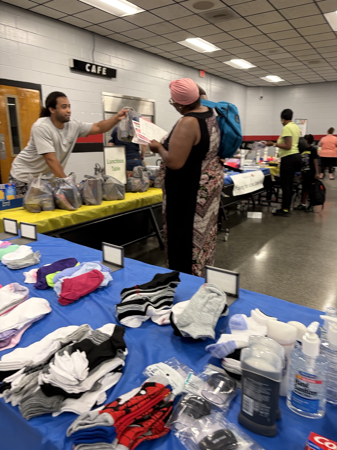 Volunteer distributing a lunchbox supply bag to a community member.