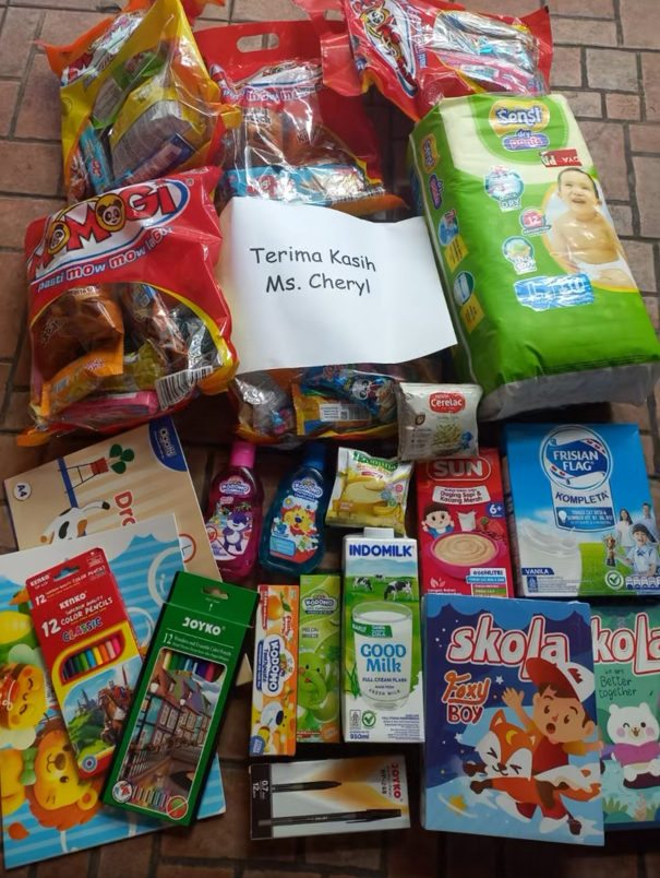 Community supplies purchased in Indonesia through Ms. Cheryl's contribution, including baby products, food, milk, and school supplies.